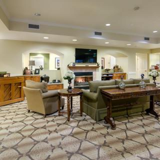 A modern living room with comfortable seating and a central television above a fireplace.