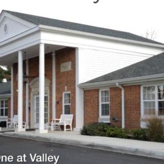 A brick building with white columns and multiple windows.