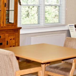 A cozy dining room with a wooden table and chairs next to a window.