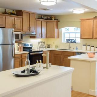 A modern kitchen with wooden cabinets, stainless steel appliances, and a spacious island.