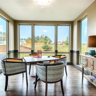 A modern dining room with large windows allowing natural light to illuminate the space.