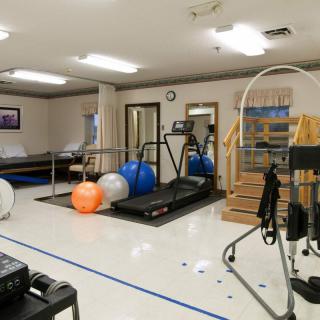 A rehabilitation gym equipped with treadmills and exercise balls for physical therapy.