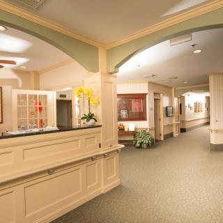 A modern interior lobby with a reception desk and hallway.