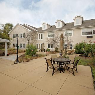 A residential building with an outdoor patio featuring a table and chairs.