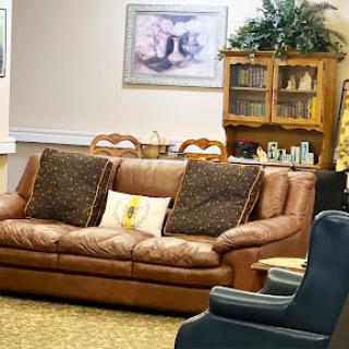 A comfortable living room setting featuring a leather sofa, armchair, and decorative elements.