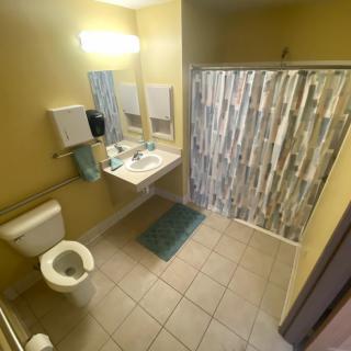 A clean, modern bathroom with a shower, toilet, and sink.