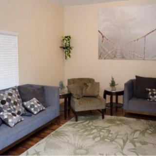 A cozy living room with two sofas, an armchair, and stylish decor.