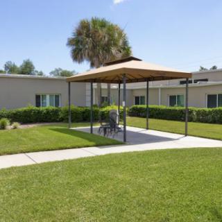 A sunny garden area with a gazebo and well-maintained lawn.