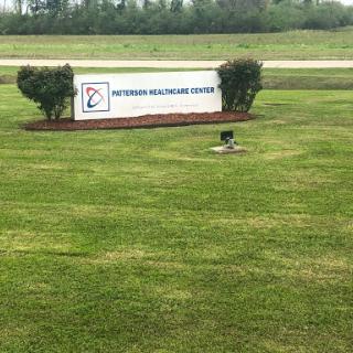 Signage for a healthcare center surrounded by a well-maintained lawn.