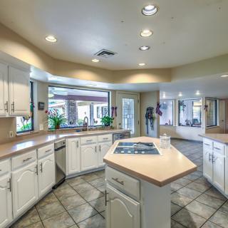 A spacious modern kitchen with white cabinets and a central island.