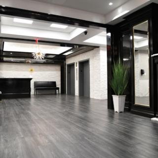 A sleek and modern lobby featuring elevators, contemporary furniture, and elegant lighting.
