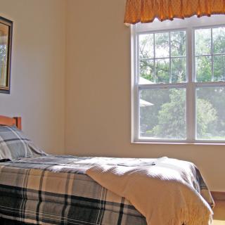 A cozy bedroom with sunlight filtering through the window.