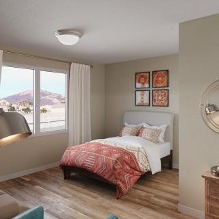A cozy bedroom with a single bed, colorful bedding, and decorative artwork on the wall.
