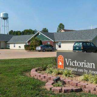 A nursing home with a visible sign, parking area, and nearby water tower.