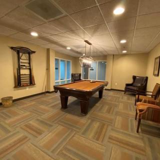 A cozy game room featuring a pool table and comfortable seating.