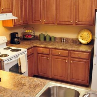 A cozy kitchen with wooden cabinets and a marble countertop.
