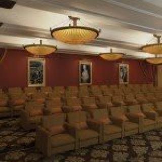 A well-lit theater room with rows of comfortable seating and elegant decor.