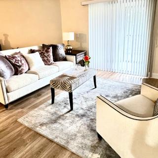 A cozy and stylish living room featuring a comfortable sofa, elegant chairs, and tasteful decor.