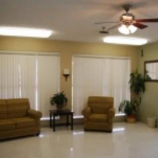 A cozy living room with sofas, chairs, and a ceiling fan.
