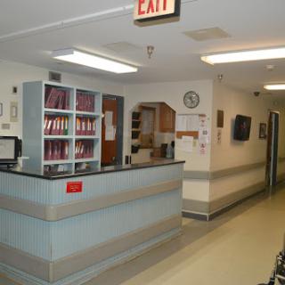 The reception area of a hospital, featuring an organized front desk and access to waiting areas.