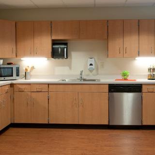 A modern kitchen featuring wooden cabinets and essential appliances.