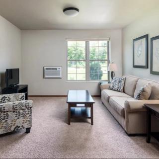 A cozy living room with a sofa, coffee table, and a TV.