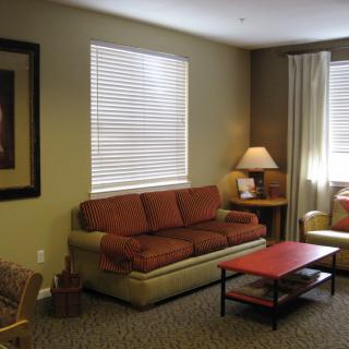 A cozy living room with a sofa, coffee table, and lamp.