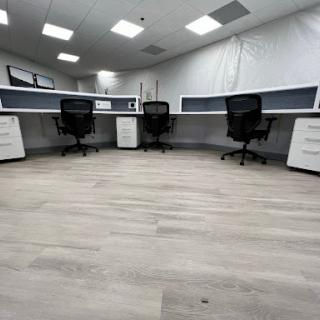 A modern office space featuring minimalist desks and ergonomic chairs.