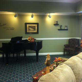 A cozy living room featuring a grand piano and elegant decor.