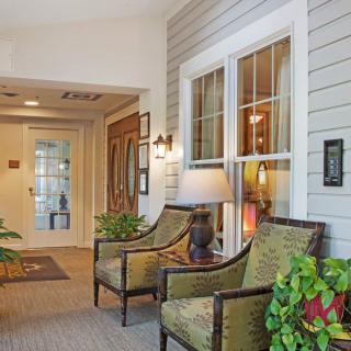A cozy lobby area with chairs and indoor plants.