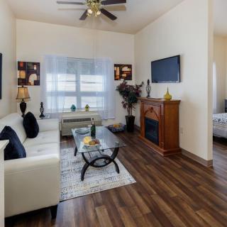 A modern living room with a white sofa, wooden flooring, and a cozy atmosphere.