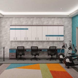A modern office space with desks, chairs, cabinets, and a colorful geometric rug.