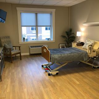 A well-lit patient room in a hospital featuring modern furnishings and amenities.