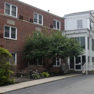 A view of a residential building showcasing brick architecture and a welcoming entrance.