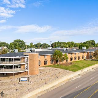 Aerial view of a modern building undergoing construction, with a clear blue sky overhead.