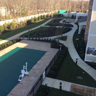 Aerial view of a landscaped garden with a covered pool and winding pathways.