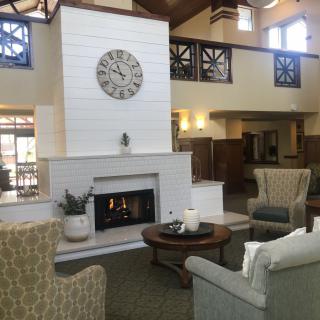 A cozy living room with a modern design, featuring a central fireplace and comfortable seating.