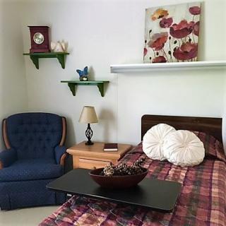 Cozy and inviting bedroom setup with a comfortable chair and decorative elements.