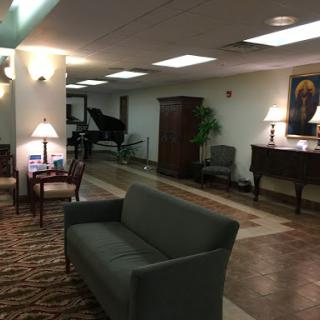 A serene lobby area featuring comfortable seating and a piano, ideal for relaxation.