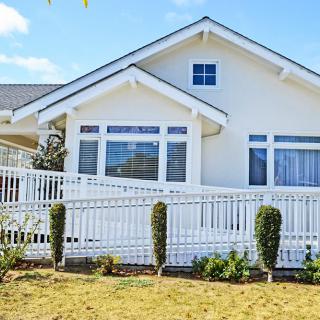 A charming white house with a front yard and white picket fence.