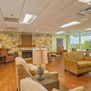 A cozy lobby area with comfortable seating, a stone fireplace, and large windows providing natural light.