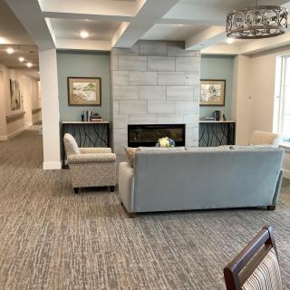 A modern living room with a cozy seating area around a fireplace.