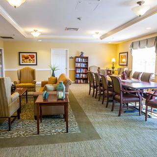 A cozy living and dining area with comfortable seating, a large table, and warm lighting.