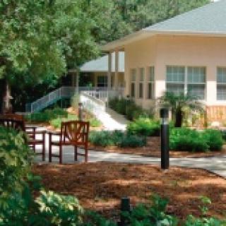 A tranquil outdoor garden area with chairs and a modern building in the background.