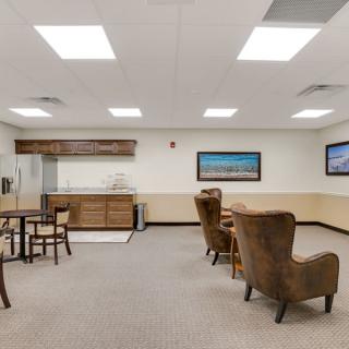 A spacious interior room featuring comfortable seating and tables, ideal for meetings or relaxation.