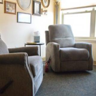 A cozy living room with two recliner chairs near a window.
