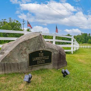 A memorial stone marker with flags in a grassy outdoor setting.