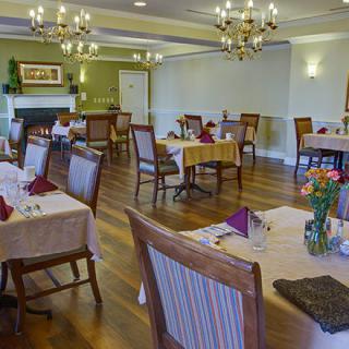 A well-appointed dining room with elegant chandeliers and neatly arranged tables.