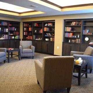 A cozy library room with armchairs and bookshelves.