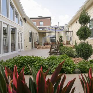 A well-maintained courtyard garden featuring lush greenery and a small patio area.